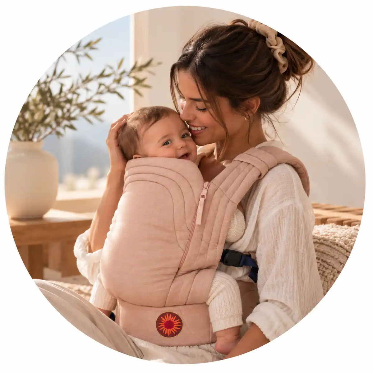 Mãe a abraçar o bebé no marsúpio Moova rosa, num ambiente acolhedor e luminoso.