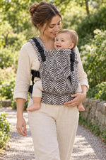 Mulher com bebé no marsúpio Emeibaby Easy Leaves Dark Baby Size num jardim